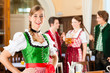 Young people in traditional Bavarian Tracht in restaurant or pub