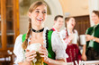 Foto: Young people in traditional Bavarian Tracht in restaurant or pub Young people in traditional Bavarian Tracht in restaurant or pub