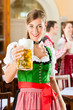 Photo: Young people in traditional Bavarian Tracht in restaurant or pub Young people in traditional Bavarian Tracht in restaurant or pub