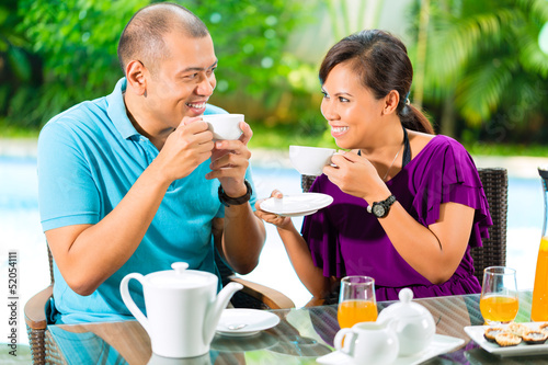 Photo: Asian couple having coffee on home porch Asian couple having coffee on home porch
