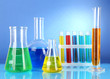 Test tubes with colorful liquids on blue background