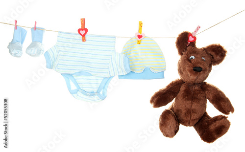 Photo: Baby clothes hanging on clothesline, isolated on white Baby clothes hanging on clothesline, isolated on white