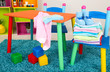 Small and colorful table and chairs with baby clothes