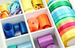 Bright silk ribbons in white wooden box, close up