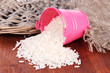 Overturned bucket with grains on wooden background