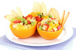 Fruit salad in hollowed-out orange isolated on white