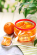 Orange jam with zest and tangerines, on white wooden table