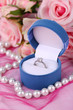Rose and engagement ring on pink cloth