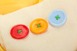 Three buttons on beige and yellow cloth