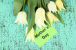 Beautiful white tulips on color wooden background