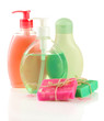 Cosmetics bottles and natural handmade soap on green background