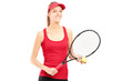 A smiling female holding a tennis racket and a ball