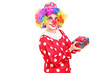 A male clown with joyful expression on his face holding a gift