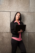 Frau mit Laptop an der Mauer
