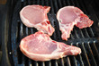 Three Raw Pork Chops on a Grill