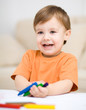 Foto: Little boy is drawing on white paper Little boy is drawing on white paper