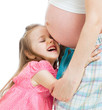 happy kid girl hugging pregnant mother's belly