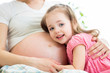 Foto: happy kid girl hugging pregnant mother's belly happy kid girl hugging pregnant mother's belly