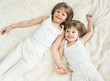 happy little sisters lying on back top view