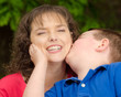 Photo: Happy mother laughing at kiss from son Happy mother laughing at kiss from son