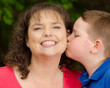 Photo: Happy mother laughing at kiss from son Happy mother laughing at kiss from son