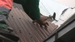 Man on the ladder hammering roof sheet