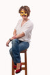 beautiful young woman sitting on a chair with carnival mask