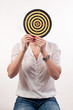 Young woman with dartboard in front of face, Bull's Eye