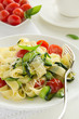 Pasta tagliatelle with zucchini and tomatoes.