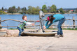 Kinder spielen mit Pumpe am See