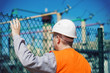 Photo: Electrical engineer touched a hand to the fence Electrical engineer touched a hand to the fence
