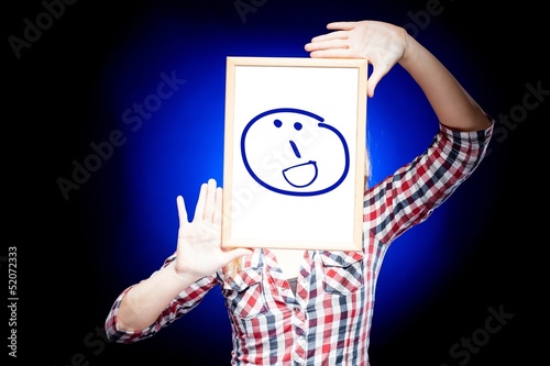 Photo: Woman showing grin emoticon in front of face Woman showing grin emoticon in front of face
