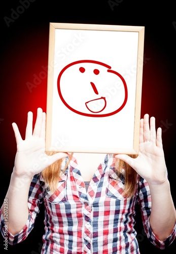 Photo: Woman showing grin emoticon in front of face Woman showing grin emoticon in front of face