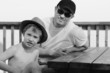 Happy father and his son sitting on summer cafe on the beach