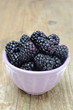bowl of fresh blackberries on a wooden background
