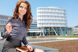 Portrait of young business woman on building background