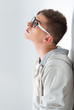 Portrait of young fashionable man leaning on white wall and wear