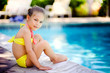 Pretty little girl playing in outdoor swimming pool and have a f