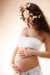 Foto: Portrait of a beautiful pregnant woman on bege background Portrait of a beautiful pregnant woman on bege background