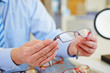 Hands holding glasses at optician