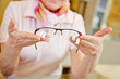 Foto: Hands of optician offering glasses Hands of optician offering glasses