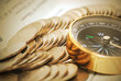 Coins and compass on bank book account in vintage color