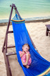 Photo: Little baby girl asleep outdoors on a hammock at the sea beach Little baby girl asleep outdoors on a hammock at the sea beach
