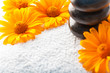 Photo: Spa stones on white towel with orange golden-daisy flower Spa stones on white towel with orange golden-daisy flower