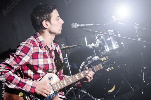 Photo: Man playing guitar during concert Man playing guitar during concert