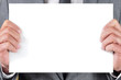 man in suit holding a blank signboard