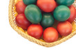 Colored Easter eggs in straw plate isolated on white