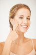 Photo: woman pointing at her cheek woman pointing at her cheek