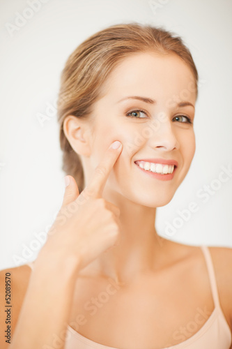 Photo: woman pointing at her cheek woman pointing at her cheek