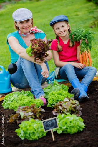 Photo: Gardening, vegetable - girl helping mother in the garden Gardening, vegetable - girl helping mother in the garden
